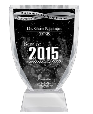 The image shows a clear glass award plaque with text indicating recognition for  Best of Manhattan Dentist 2015  and the name  Dr. Gano Nazarian.  The plaque also includes a laurel wreath symbol, and there is a black background with white stars above the plaque.