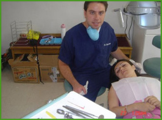 The image shows a man in scrubs standing next to a dental chair with a patient inside, both located in a room with medical equipment.