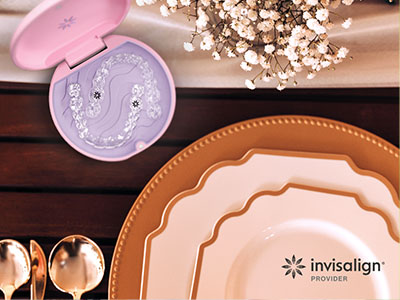 The image displays a collection of tableware items including plates, bowls, and a tray, with a focus on a purple object resembling a toothbrush holder, set against a blurred background that suggests a dining setup, possibly for a product advertisement.