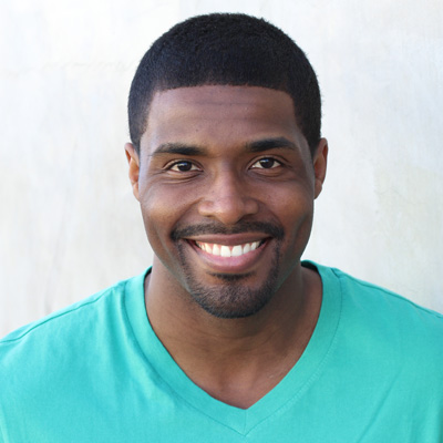 An elderly couple sharing a warm embrace while posing for a photo outdoors.